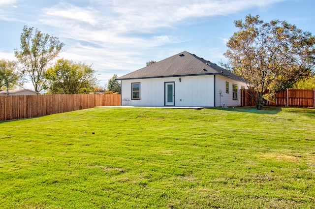 back of property featuring a lawn