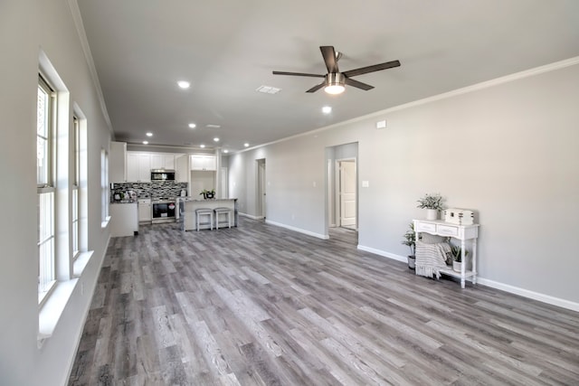 living room featuring ornamental molding, light hardwood / wood-style floors, and plenty of natural light