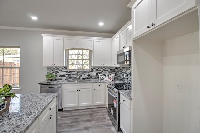 kitchen featuring a wealth of natural light, white cabinetry, and appliances with stainless steel finishes