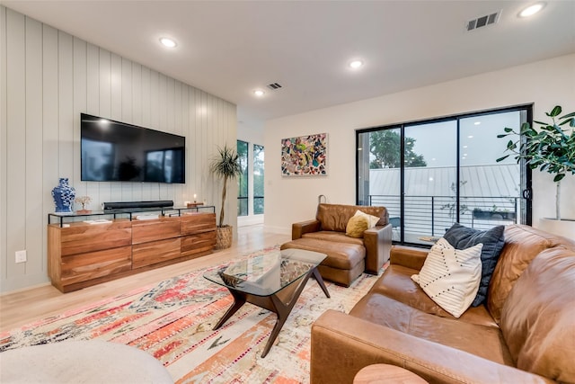 living room featuring wood walls and light hardwood / wood-style flooring