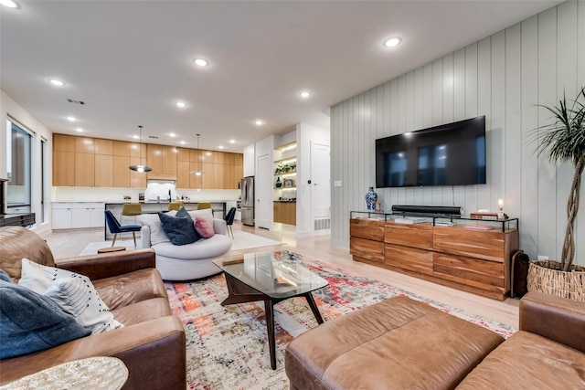 living room featuring wood walls and light hardwood / wood-style floors