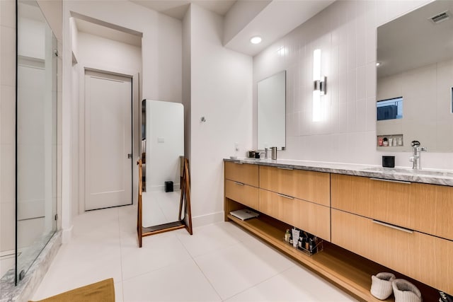 bathroom with tile patterned flooring, vanity, and tile walls