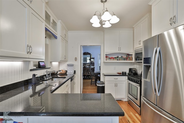 kitchen featuring white cabinetry, appliances with stainless steel finishes, sink, light hardwood / wood-style floors, and a chandelier