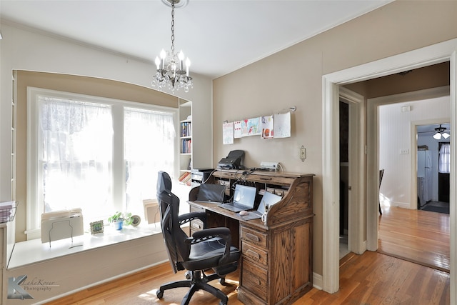 office space with hardwood / wood-style floors and ceiling fan with notable chandelier