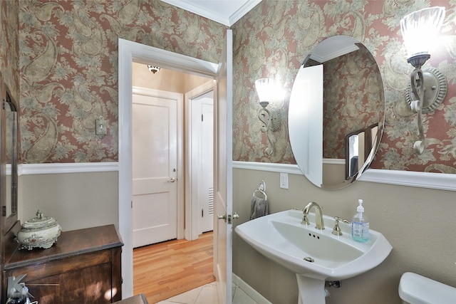 bathroom featuring toilet, sink, hardwood / wood-style floors, and ornamental molding