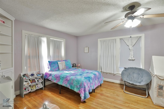 bedroom featuring a textured ceiling, wood-type flooring, and ceiling fan