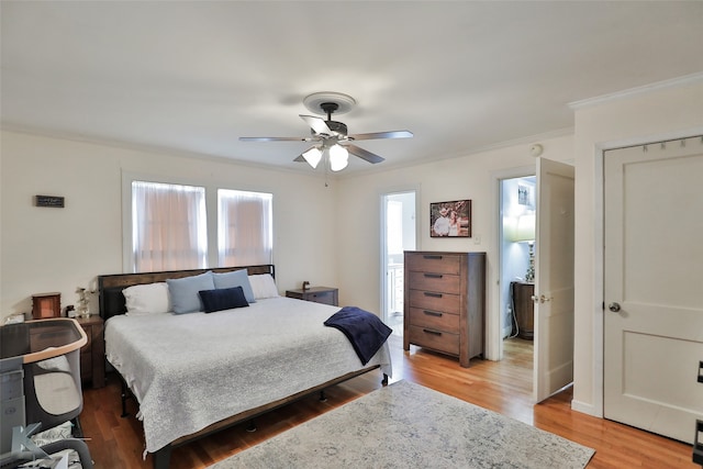 bedroom with ornamental molding, wood-type flooring, and ceiling fan