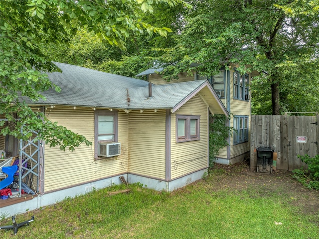 view of property exterior featuring a lawn and cooling unit