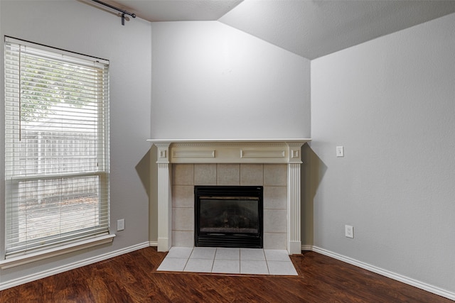 room details with a tiled fireplace and hardwood / wood-style floors