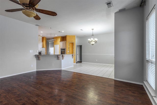 1005 Carina Ct, Arlington, TX 76013 - unfurnished living room featuring ceiling fan, plenty of natural light, a chandelier, light wood-style floors, and recessed lighting
