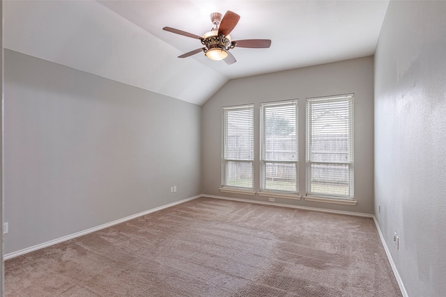 spare room with light colored carpet, lofted ceiling, and ceiling fan