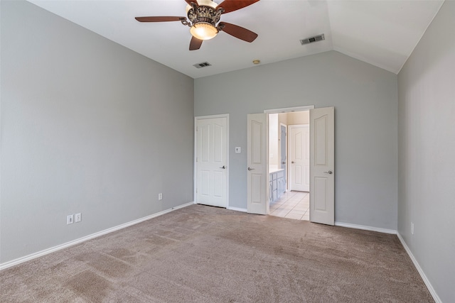 empty room featuring light carpet, ceiling fan, and vaulted ceiling