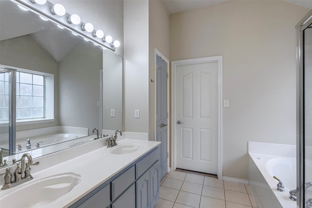 bathroom featuring vanity, tile patterned floors, a bathtub, and lofted ceiling