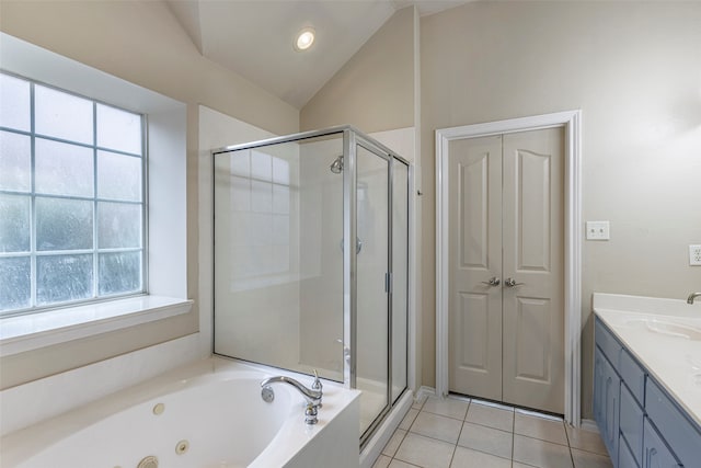 bathroom with independent shower and bath, vanity, vaulted ceiling, and tile patterned flooring