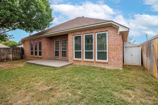 back of property featuring a shed, a yard, and a patio