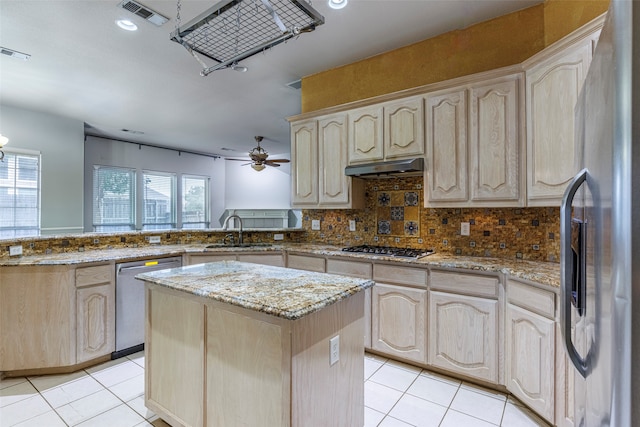 kitchen featuring light brown cabinets, kitchen peninsula, stainless steel appliances, and plenty of natural light