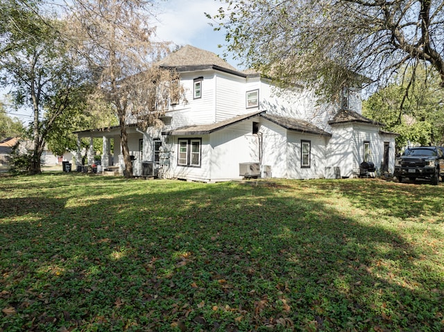 rear view of property with a lawn