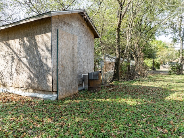 view of side of home with a yard and a storage shed