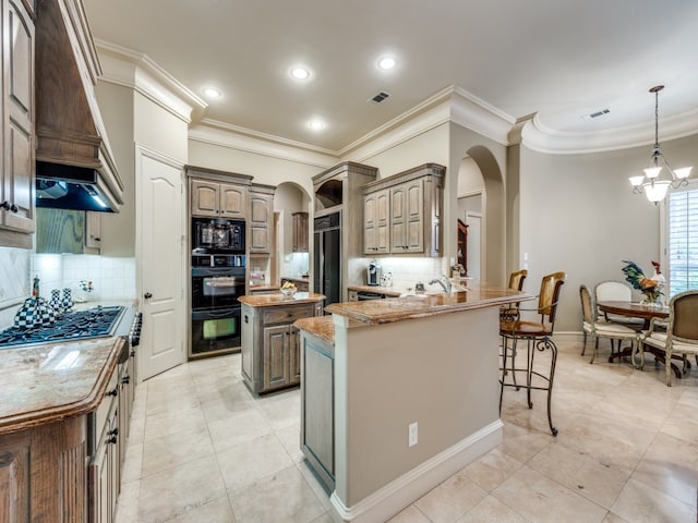 kitchen with black appliances, kitchen peninsula, tasteful backsplash, crown molding, and a kitchen island