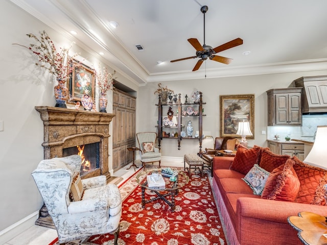 living room featuring ceiling fan, light hardwood / wood-style floors, a premium fireplace, and crown molding