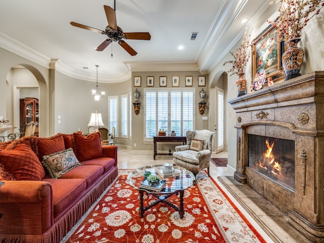 living room with ceiling fan, a high end fireplace, and crown molding