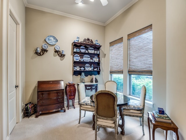 dining room featuring ornamental molding, light colored carpet, and ceiling fan