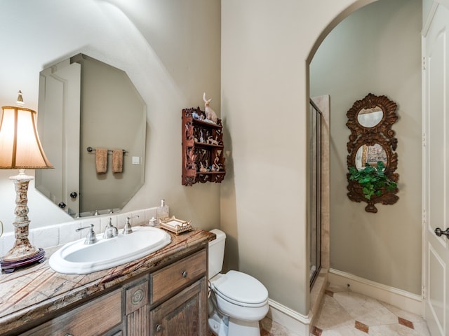 bathroom featuring walk in shower, vanity, tile patterned floors, and toilet