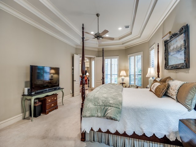 bedroom with ornamental molding, light colored carpet, ceiling fan, and a raised ceiling