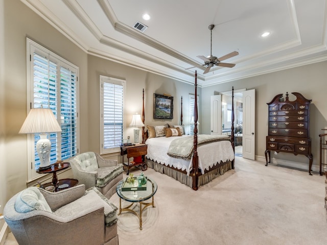 bedroom featuring light carpet, a barn door, ceiling fan, crown molding, and a raised ceiling