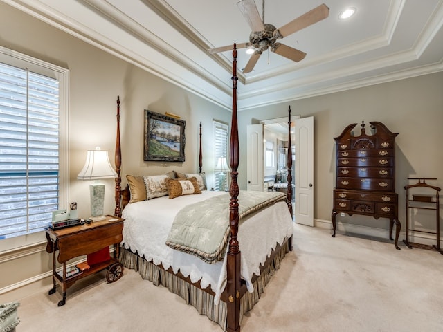 bedroom with ceiling fan, crown molding, light carpet, and a raised ceiling