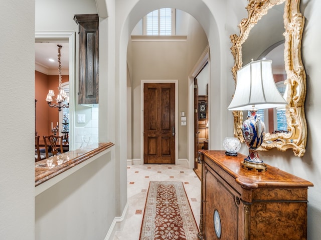 foyer entrance with a notable chandelier and crown molding