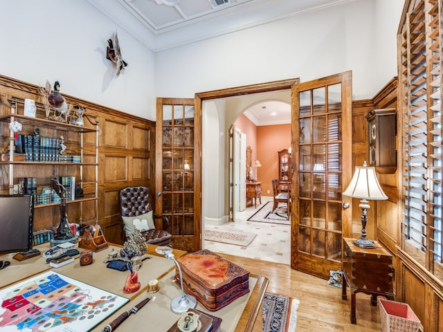 office area with light hardwood / wood-style floors, a high ceiling, and ornamental molding