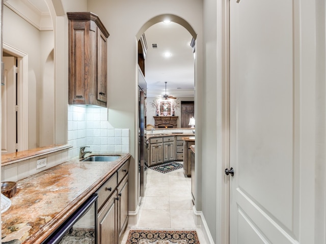 interior space featuring sink, decorative backsplash, and light tile patterned floors