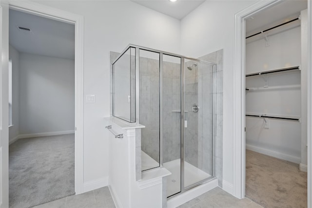 1813 Morning Mist Way, Mesquite, TX 75181 - bathroom featuring a spacious closet, a shower stall, baseboards, and tile patterned flooring