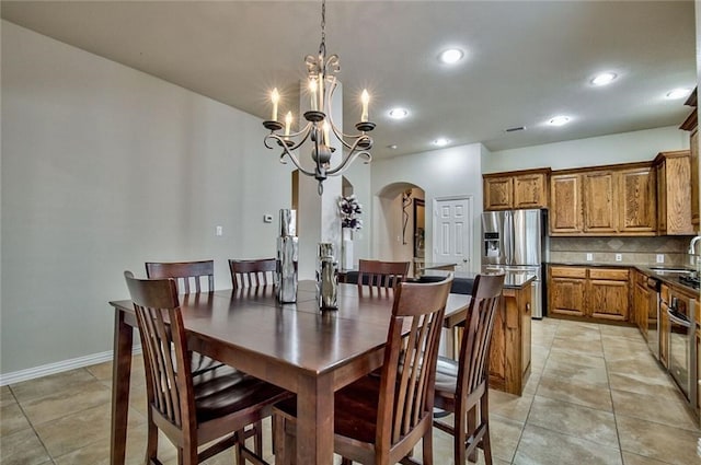 tiled dining space with an inviting chandelier and sink