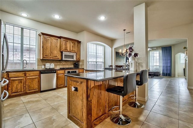 kitchen with kitchen peninsula, a healthy amount of sunlight, sink, and stainless steel appliances