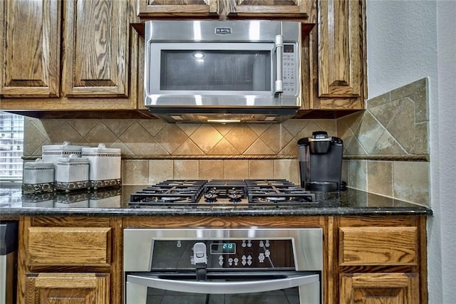 kitchen featuring dark stone counters, appliances with stainless steel finishes, and tasteful backsplash