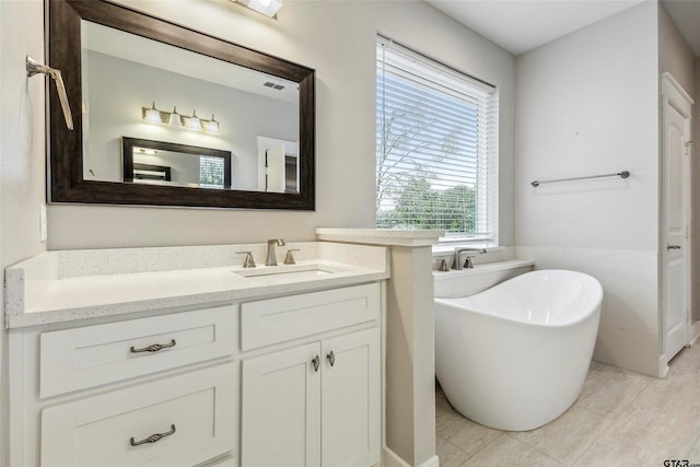 bathroom featuring a bathtub, vanity, and tile patterned floors