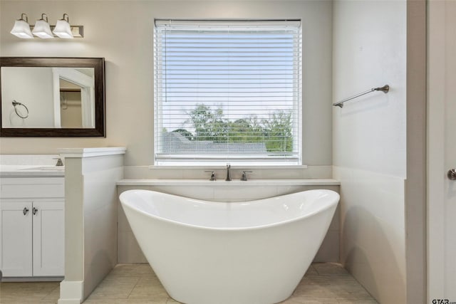 bathroom with vanity, tile patterned flooring, a bathing tub, and tile walls