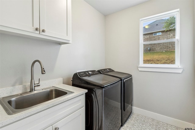 clothes washing area featuring cabinets, washer and clothes dryer, sink, and light tile patterned floors