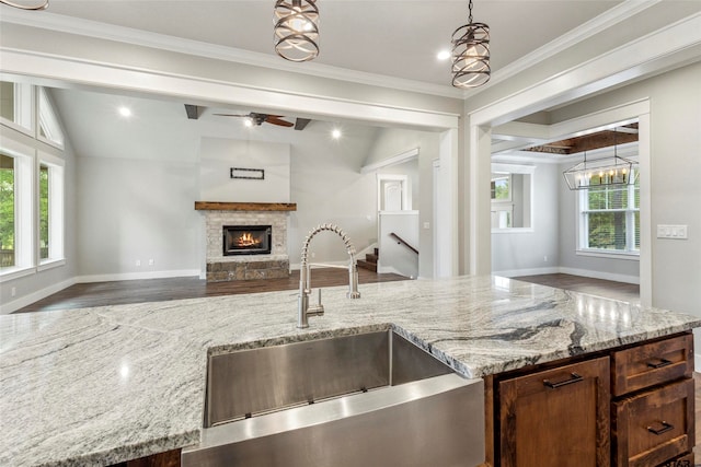 kitchen with a fireplace, decorative light fixtures, sink, and plenty of natural light