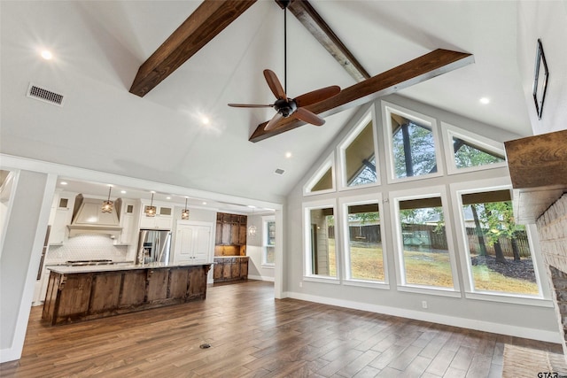 living room featuring dark wood-type flooring, ceiling fan with notable chandelier, beam ceiling, and high vaulted ceiling