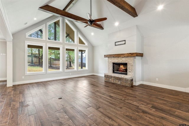 unfurnished living room featuring high vaulted ceiling, dark hardwood / wood-style flooring, a stone fireplace, and beamed ceiling