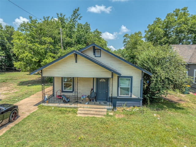 bungalow-style home featuring covered porch and a front lawn