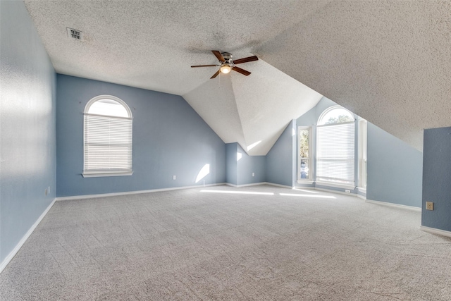 bonus room with lofted ceiling, a textured ceiling, light colored carpet, and ceiling fan