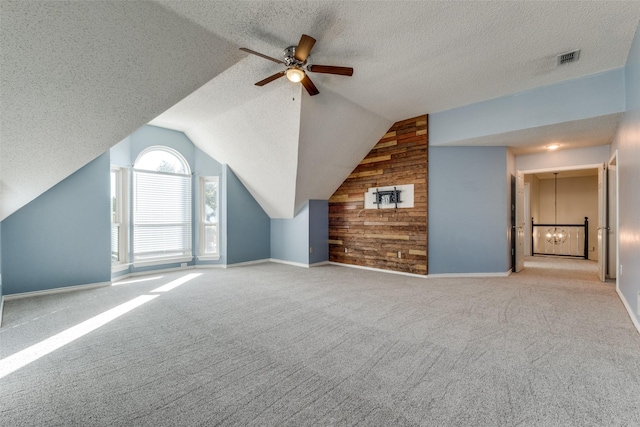 additional living space with ceiling fan, lofted ceiling, light carpet, and wooden walls