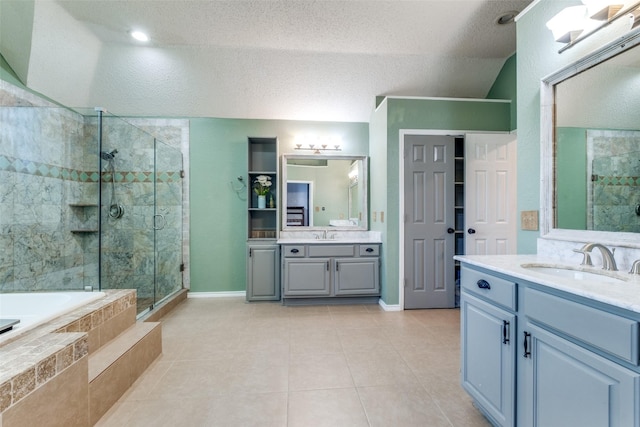 bathroom with plus walk in shower, vaulted ceiling, vanity, tile patterned floors, and a textured ceiling