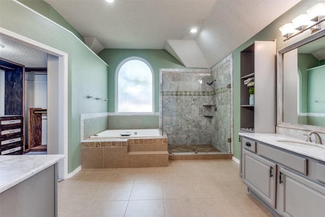 bathroom with tile patterned floors, vanity, plus walk in shower, and a textured ceiling