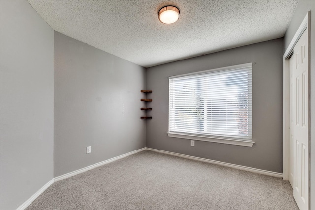 unfurnished room featuring carpet floors and a textured ceiling