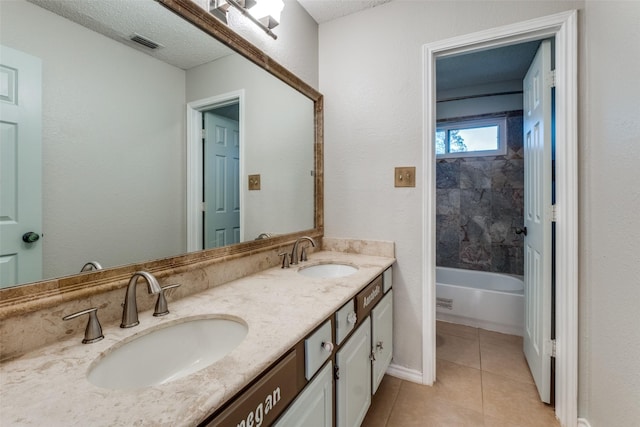 bathroom with tile patterned floors, vanity, and a textured ceiling